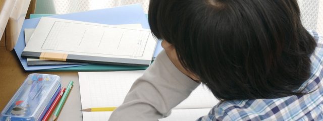 肘をついて外を見る子供